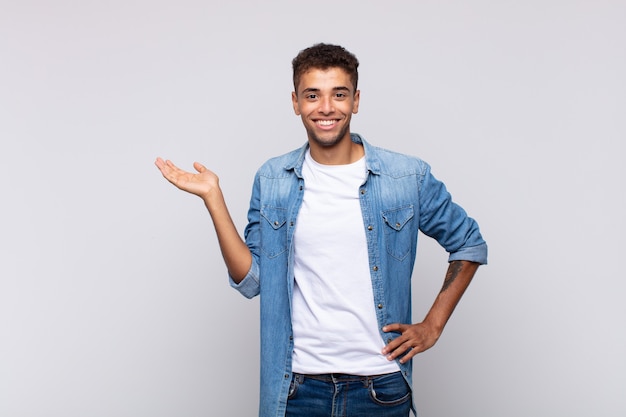 young handsome man with denim shirt posing on white wall