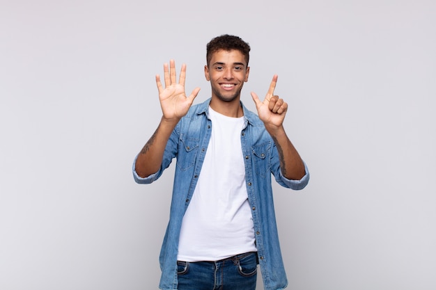 young handsome man with denim shirt posing on white wall