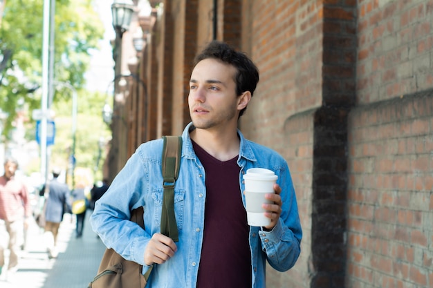 Young handsome man with disposable coffee