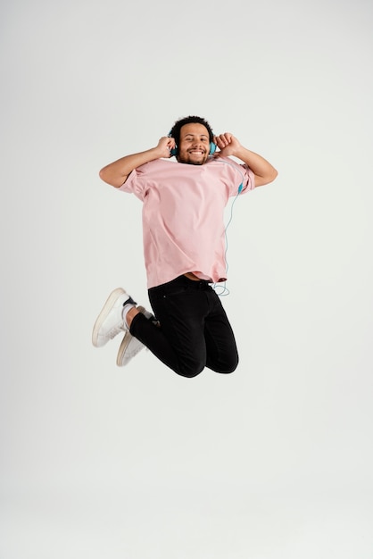 Young handsome man with headphones jumping