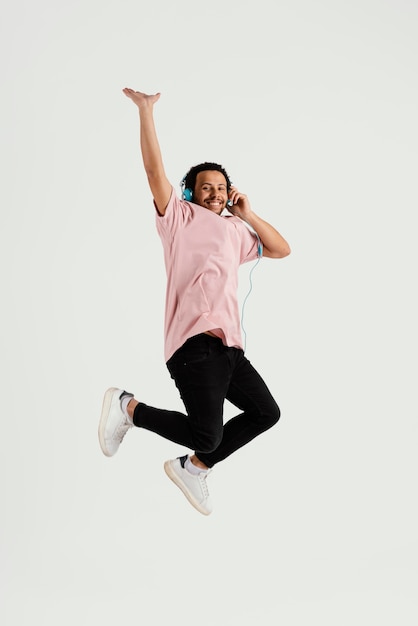 Young handsome man with headphones jumping