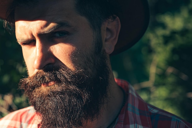 Young handsome man with long beard, mustache and trendy hairdo. Serious concentrated male model.