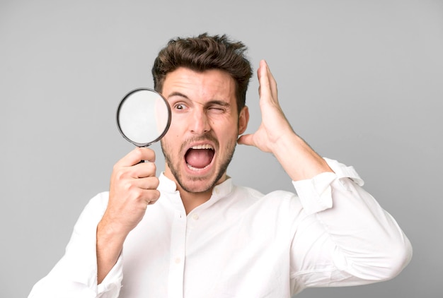 Young handsome man with a magnifying glass search or find concept