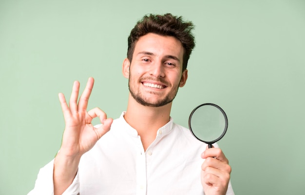 Young handsome man with a magnifying glass search or find concept