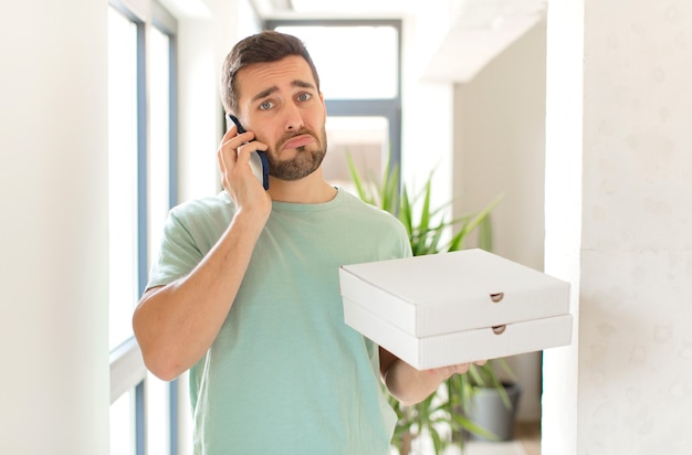 Young handsome man with take away pizza boxes at home