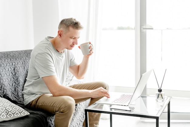 Young handsome man works at a laptop