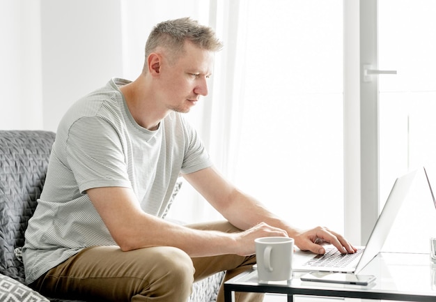 Young handsome man works at a laptop