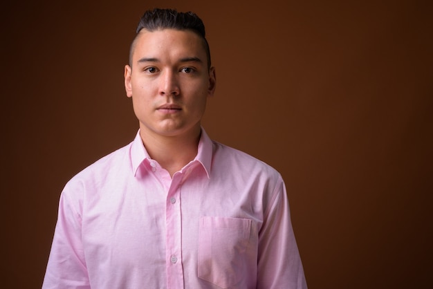 Young handsome multi-ethnic businessman on brown