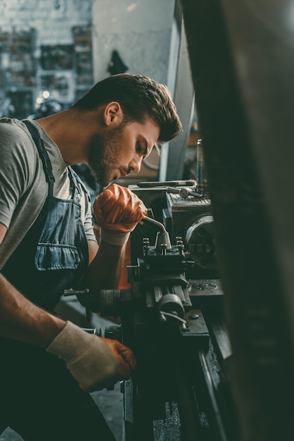 Young handsome professional repairman working in workshop