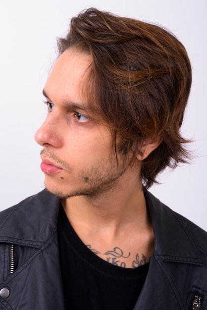  young handsome rebellious man wearing stylish clothes against white wall