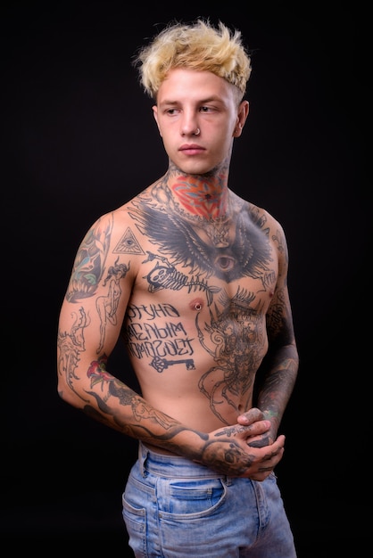 Young handsome rebellious man with tattoos shirtless