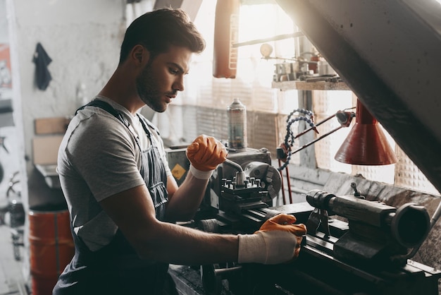 Young handsome repairman working in workshop