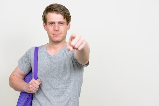 young handsome Scandinavian man ready for gym against white wall