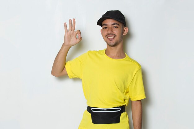 Young handsome sport man  showing a thumbs up ok gesture on white background