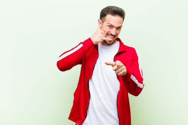 Young handsome sports man or monitor smiling cheerfully and pointing to camera