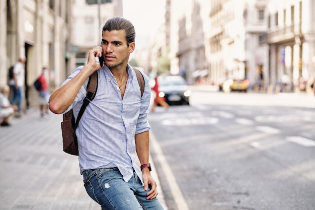 Young handsome tourist man using smartphone at Via Laietana - Barcelona