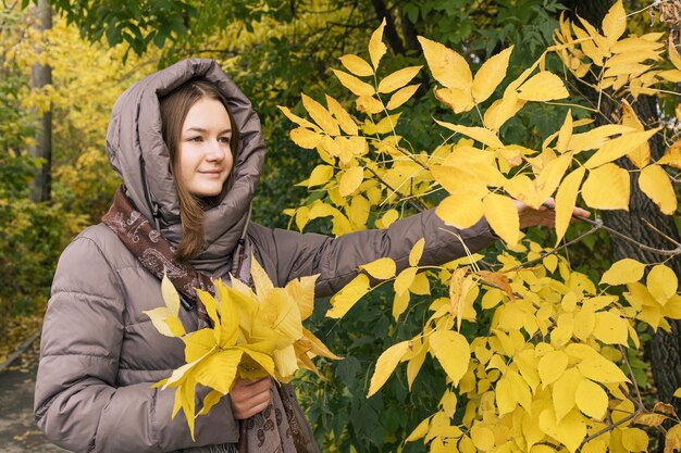 Young happiness beautiful girl with yellow leaves Colors of autumn autumn season lifestyle