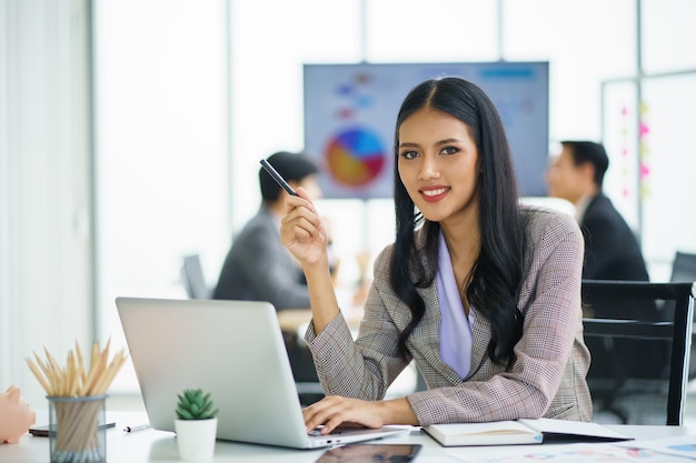 Young happy Asian businesswoman working and use a computer laptop and thinking idea for her business