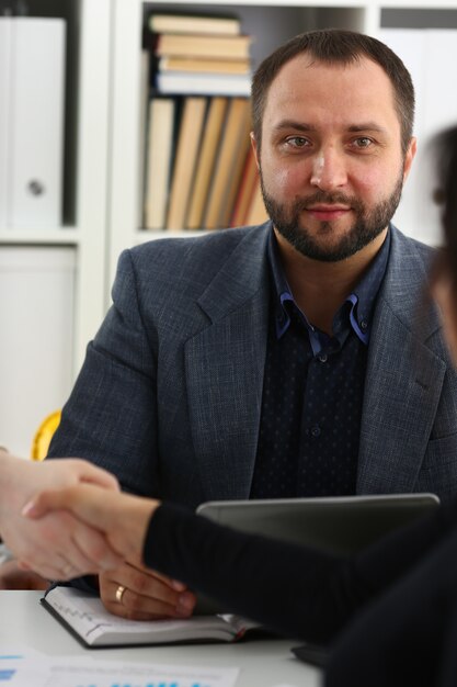 Young happy businessmen have meeting in office shake hands with each other