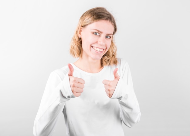 Young happy cheerful woman showing thumb up