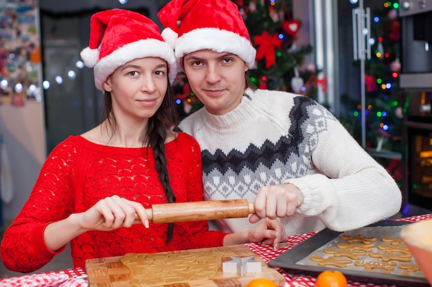 Young happy couple baking Christmas cakes