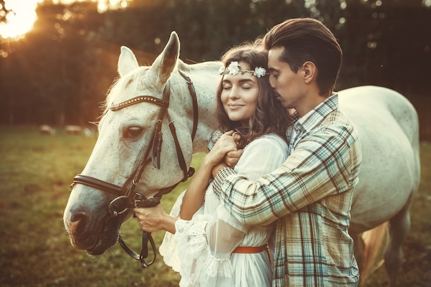 Young happy couple and beautiful horse