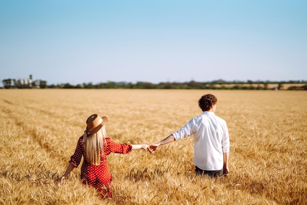 Young happy couple hugging on a wheat field on the sunset Enjoying time together