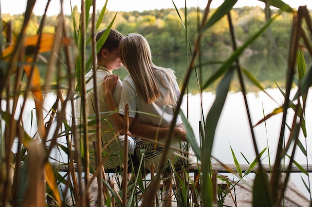 Young happy couple in love hugging and kiss on nature background man and woman on romantic date