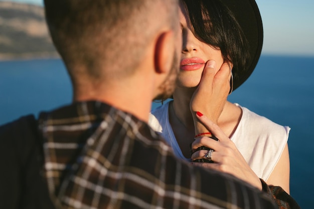 Young happy couple in love in a romantic moment when a man kisses a woman with a sea view