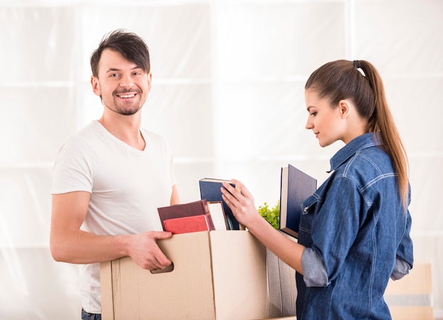 Young happy couple packing boxes.