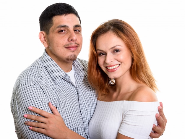 Young happy couple smiling while hugging each other and isolated on white