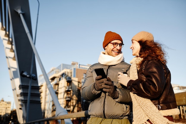 Young happy couple spending their time outdoors in the city they walking talking and laughing