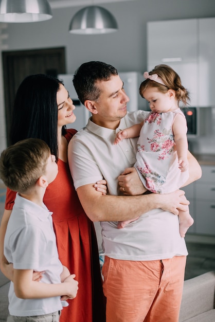 Young happy family in full standing at home