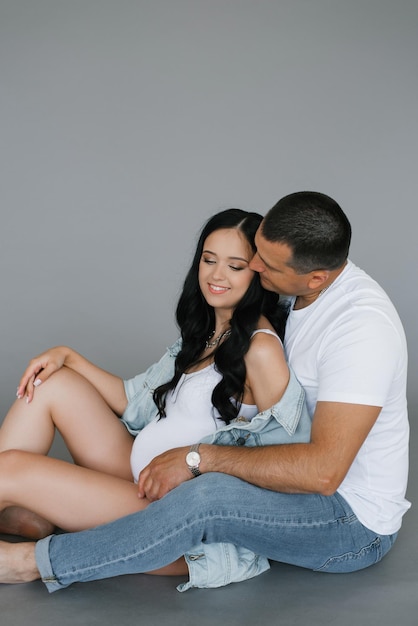 Young happy family husband and wife are expecting a baby A man embraces a pregnant woman