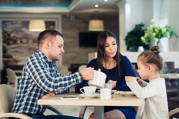 Young happy family talking in a restaurant