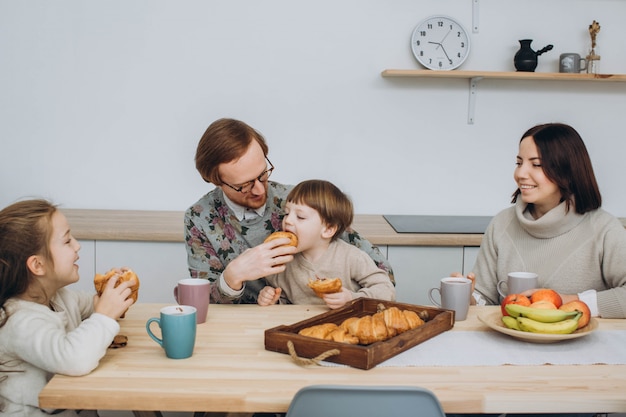 Young happy family with two kids having breakfast together.