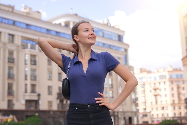 Young happy girl in city house building smile beautiful lady in residential complex City urban life