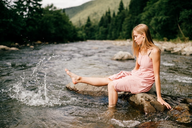 Young happy girl foot splashing water in the river