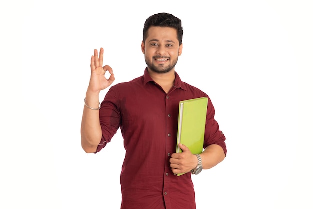 Young happy man holding and posing with the book on white background