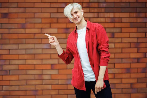 Young happy man pointing at something Man showing an offer