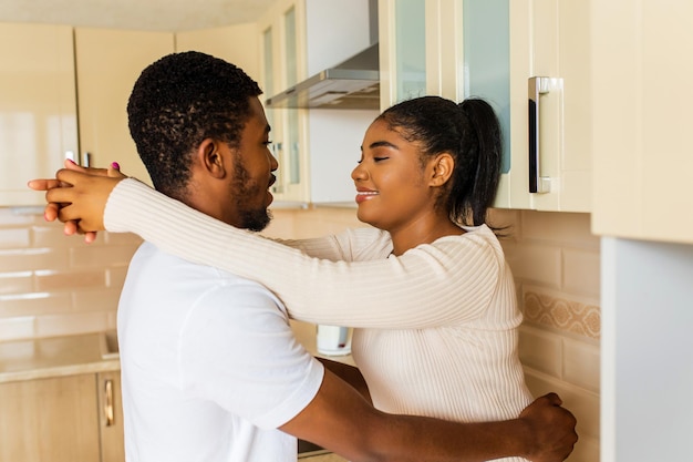 Young happy mixed race couple spending their time at home in the kitchen