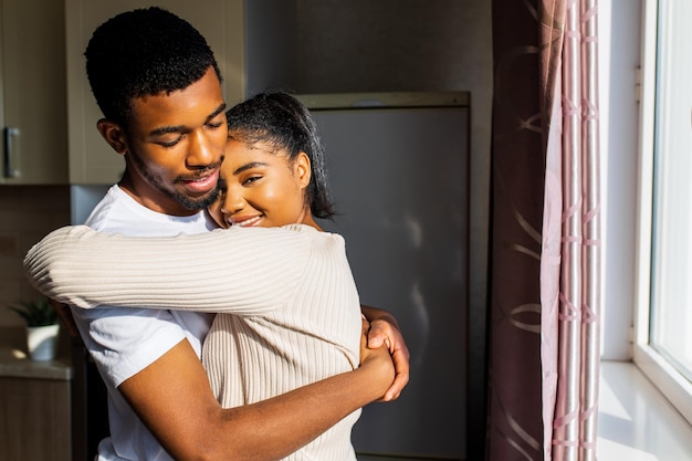 Young happy mixed race couple spending their time at home in the kitchen