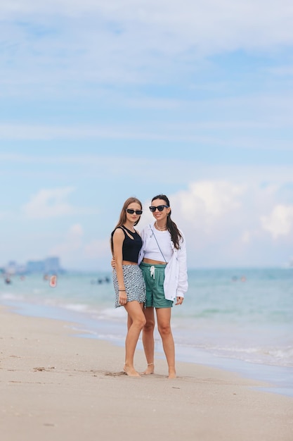 Young happy mother and and her daughter having fun on the beach