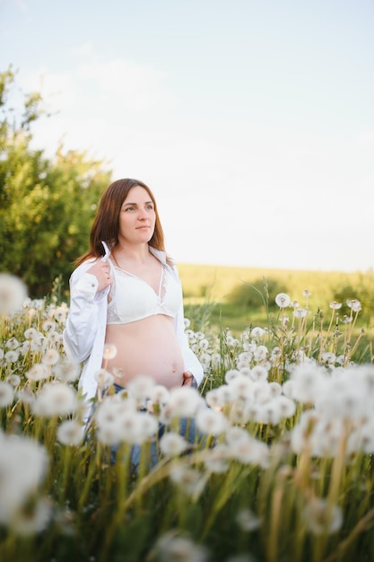 Young happy pregnant woman relaxing and enjoying life in nature Outdoor shot Copyspace