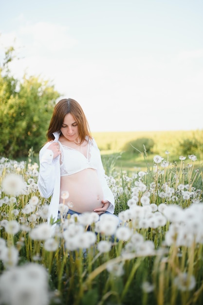 Young happy pregnant woman relaxing and enjoying life in nature Outdoor shot Copyspace