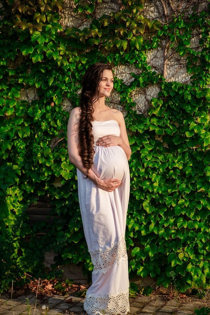 Young happy pregnant woman relaxing and enjoying life in nature Outdoor shot Copyspace