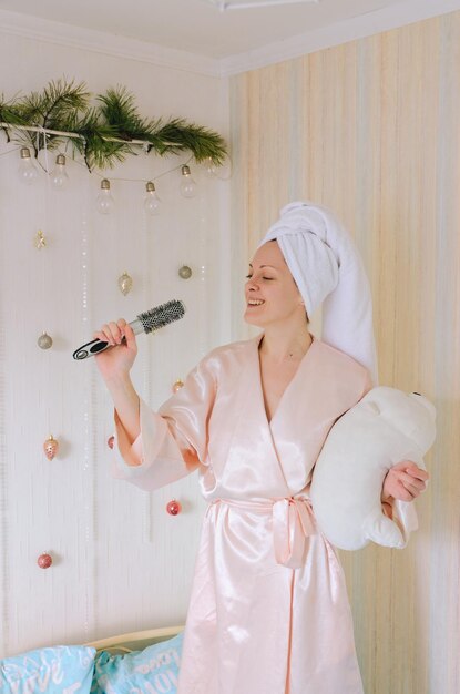 Young happy smiling woman, bride lies in bed in pajamas, bathrobe in a cozy home. Relax, dreaming