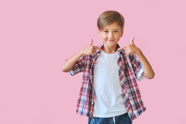 Young happy teen boy with in casuals on pink background