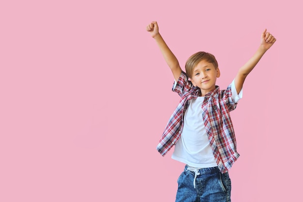 Young happy teen boy with in casuals on pink background