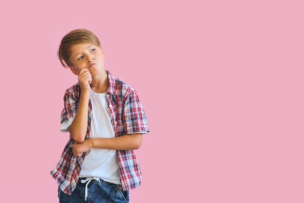 Young happy teen boy with in casuals on pink background